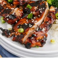 close up of sliced grilled teriyaki chicken on a plate with recipe name at the bottom