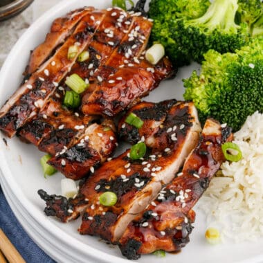 square image of sliced grilled teriyaki chicken on a plate with rice and broccoli