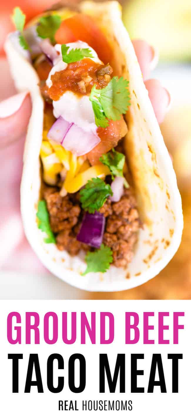 close up of a hand holding a ground beef taco