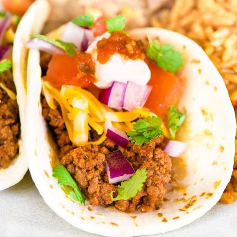 square image of a ground beef taco with toppings