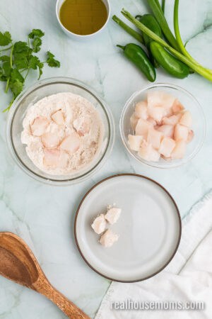 halibut pieces being dredged in seasoned flour