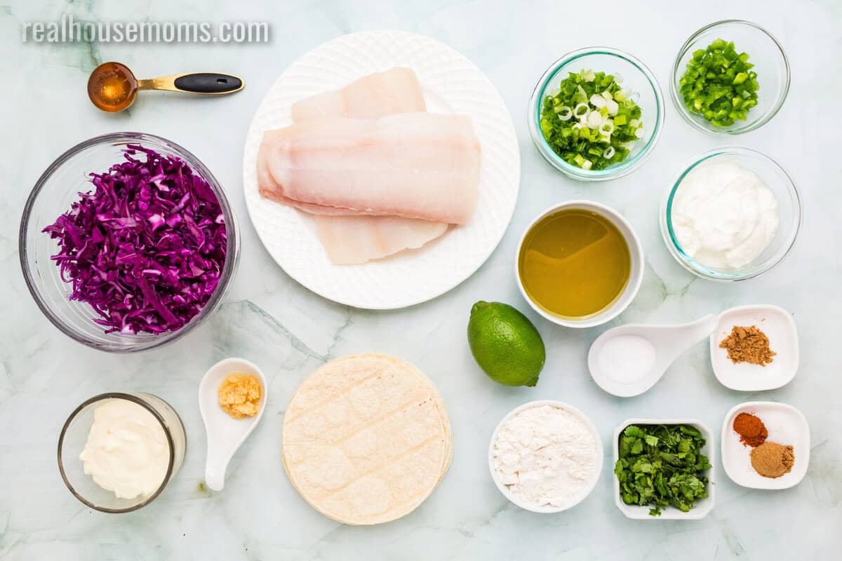 ingredients to make halibut tacos with coleslaw laid out on a counter