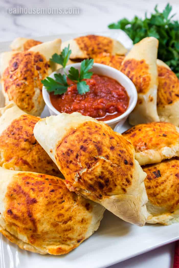 plate of mini calzones with cup of marinara sauce