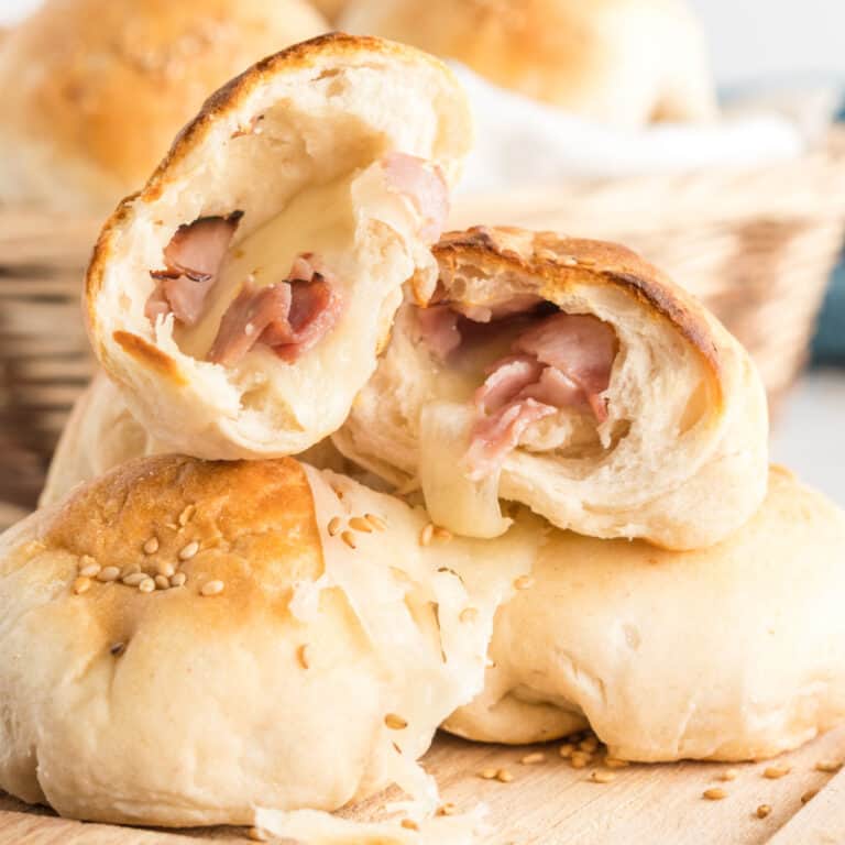 square image of a ham & cheese stuffed biscuit torn in half to show melty filling