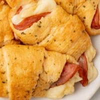 ham and cheese crescent rolls piled on a plate with recipe name at the bottom