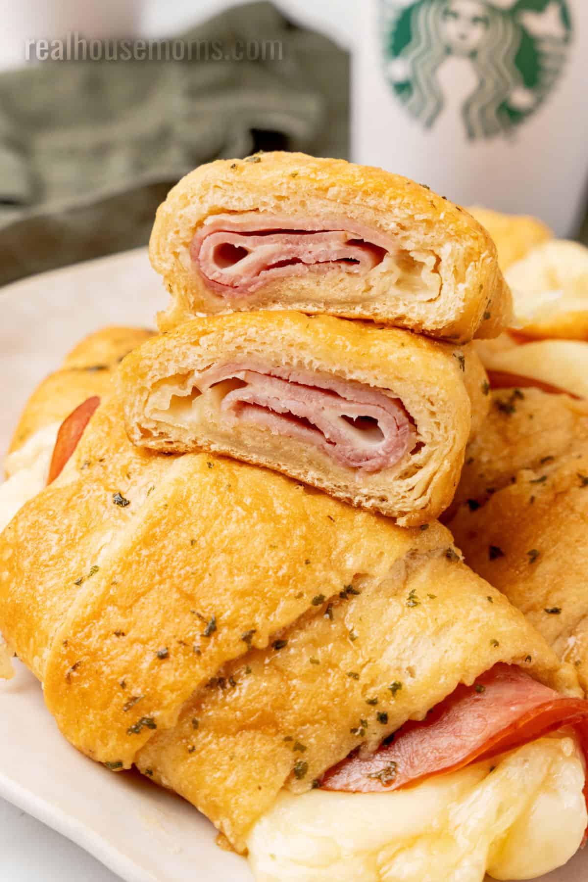 ham and cheese crescent roll cut in half to show the filling on top of other rolls
