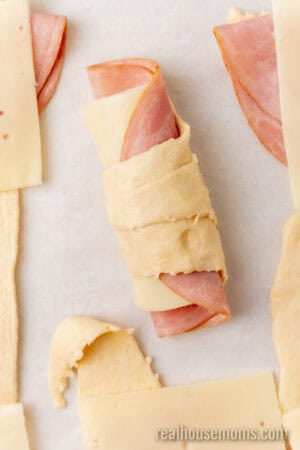close up of ham and swiss rolled up in crescent roll dough