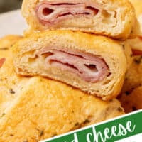 ham and cheese crescent roll cut in half to show the filling on top of other rolls with the titleof the post at the bottom