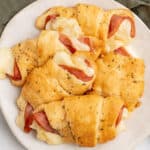 square image of ham and cheese crescent rolls piled on a plate