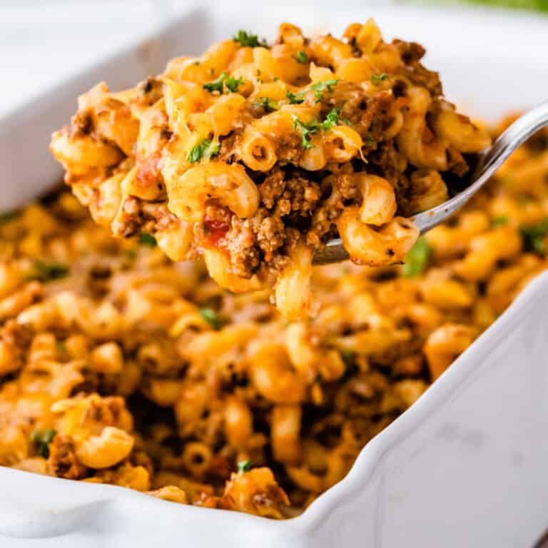 square image of a spoonful of hamburger casserole over the baking dish
