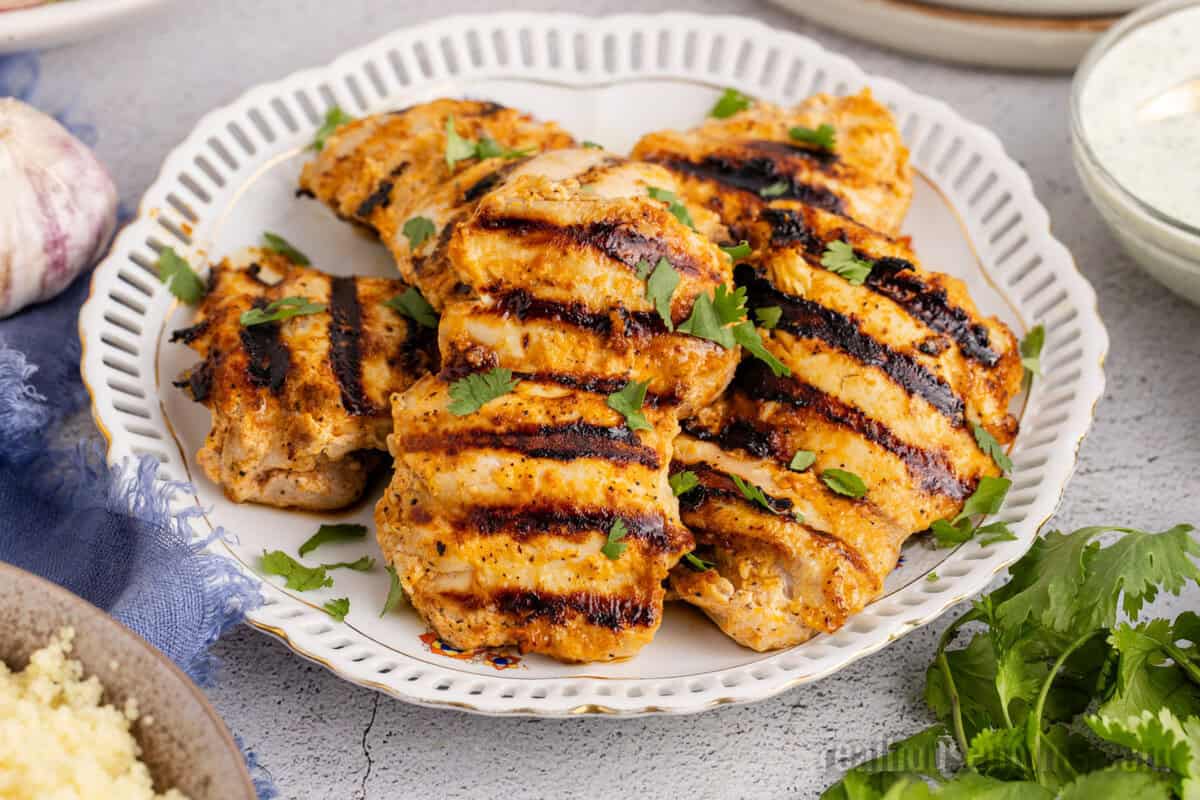grilled harissa chicken piled on a platter