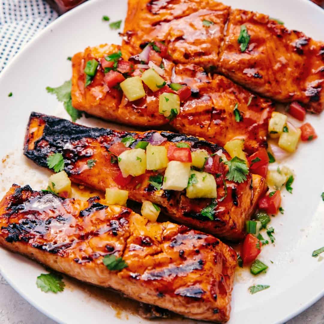 Hawaiian Grilled Salmon Filets have layers of delicious honey bourbon flavor, are grilled with apple-infused wood chips & topped off with fresh pineapple salsa!