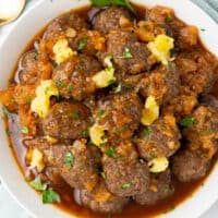 square image of hawaiian meatballs in a bowl with chopped parsley and crushed pineapple on top