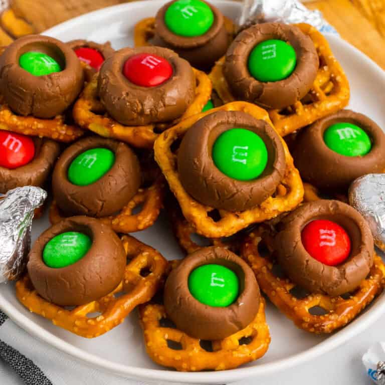 square image of hershey's kiss pretzels on a plate with unwrapped kisses