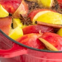 close up of apples and spices in a large pot while simmering with recipe name at the bottom