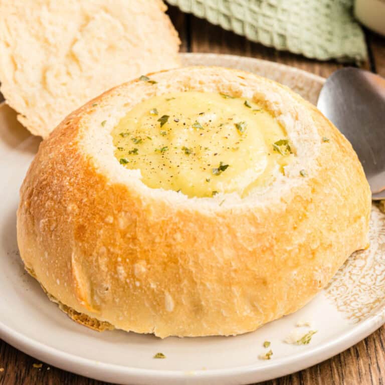 square image of broccoli cheese soup in a homemade bread bowl