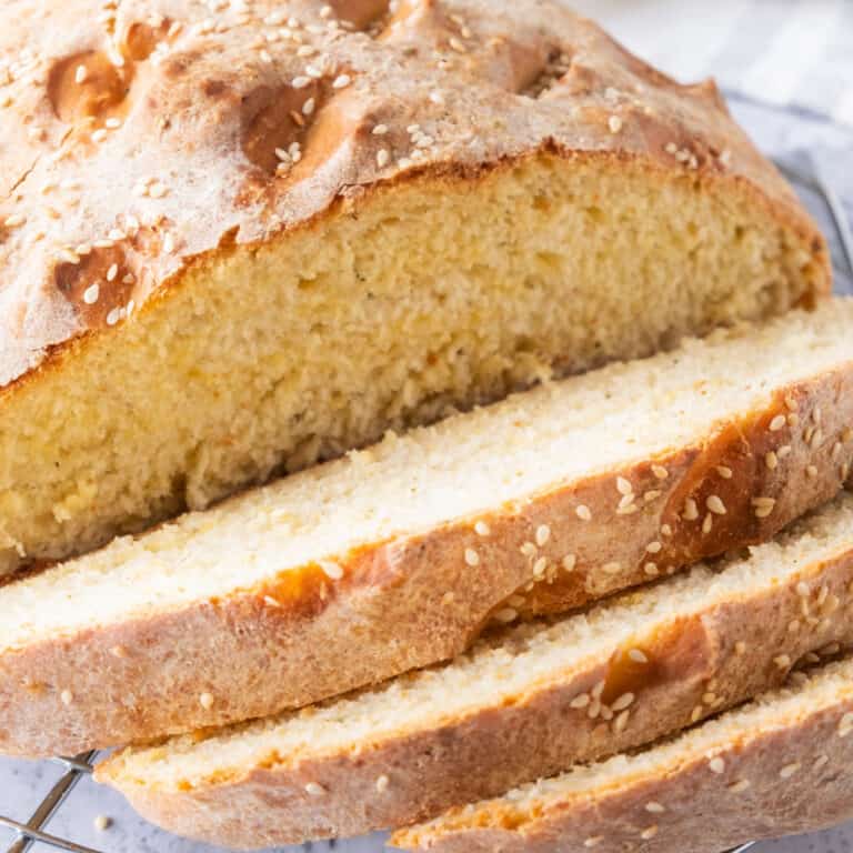 square image of a loaf of cheese bread with slices cut off to show crumb