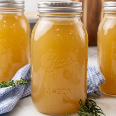 square image of homemade chicken broth in mason jars