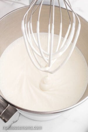 heavy cream in a stand mixer bowl after being beaten to soft peaks