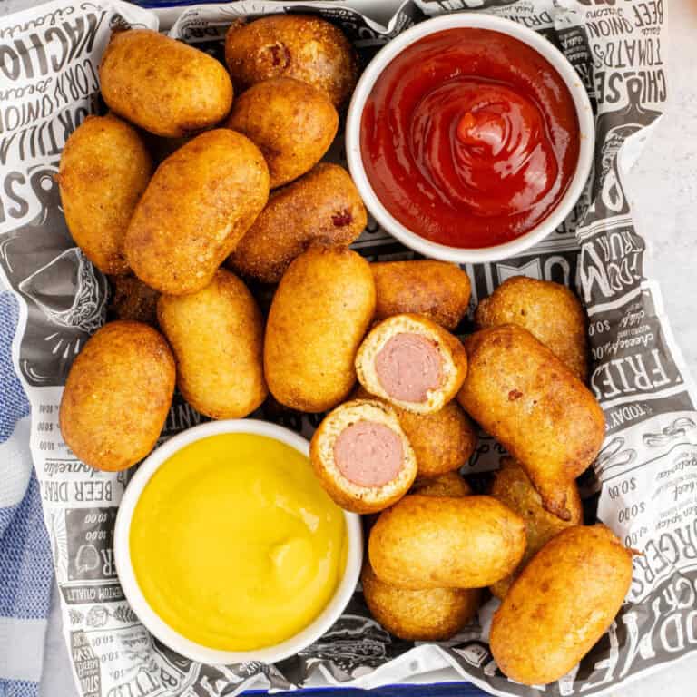 square image of corn dog bites in a basket with one cut in half