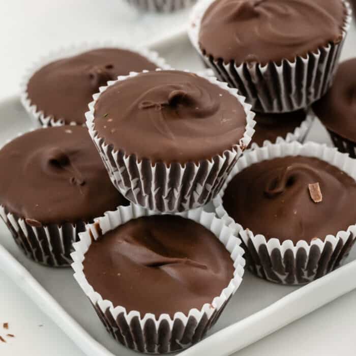 square image of homemade peanut butter cups stacked up on a platter