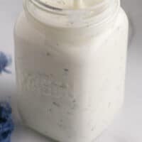 homemade ranch dressing in a mason jar with some on a spoon with recipe name at the bottom