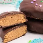 square image of homemade reese's peanut butter eggs with one cut in half to show filling