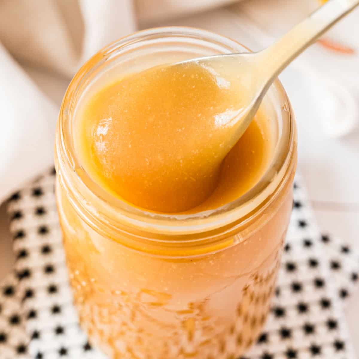 square image of a jar of salted caramel sauce with a spoon