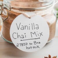 spoonful of homemade vanilla chai mix over the jar with recipe name at the bottom