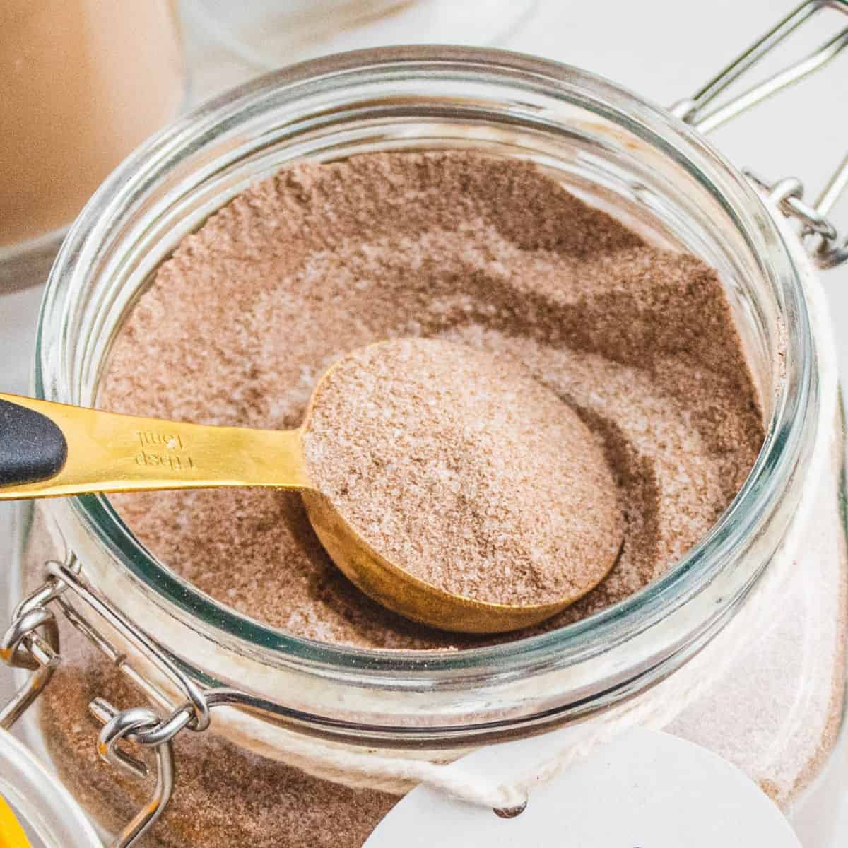 square image of a tablespoon of homemade vanilla chai mix resting in the jar