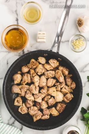cooked seasoned chicken thigh pieces in a skillet