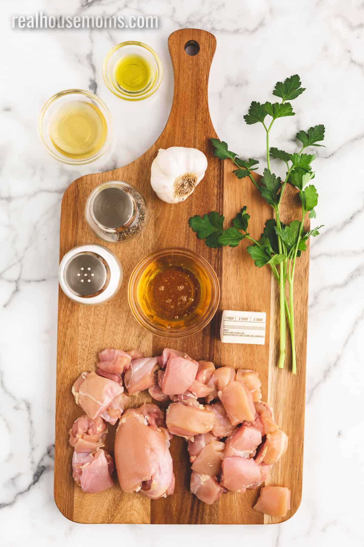 Honey Butter Chicken is better than take-out! If you want a quick and easy dinner then look no further than this juicy, sweet chicken dish! ingredients to make honey butter chicken laid out on a cutting board and in bowls