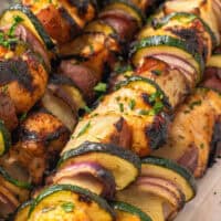 image if of honey mustard chicken kabobs piled on a cutting board with he title of the post on top with pink and black lettering