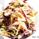 This HONEY SRIRACHA COLESLAW is made with 2 kinds of cabbage and a creamy honey dressing with a kick. Coleslaw has never tasted so good.