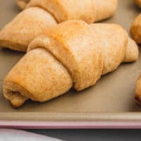 honey wheat dinner rolls on a baking sheet with recipe name at the bottom