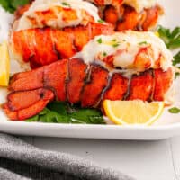 broiled lobster tails on a platter with recipe name at the bottom