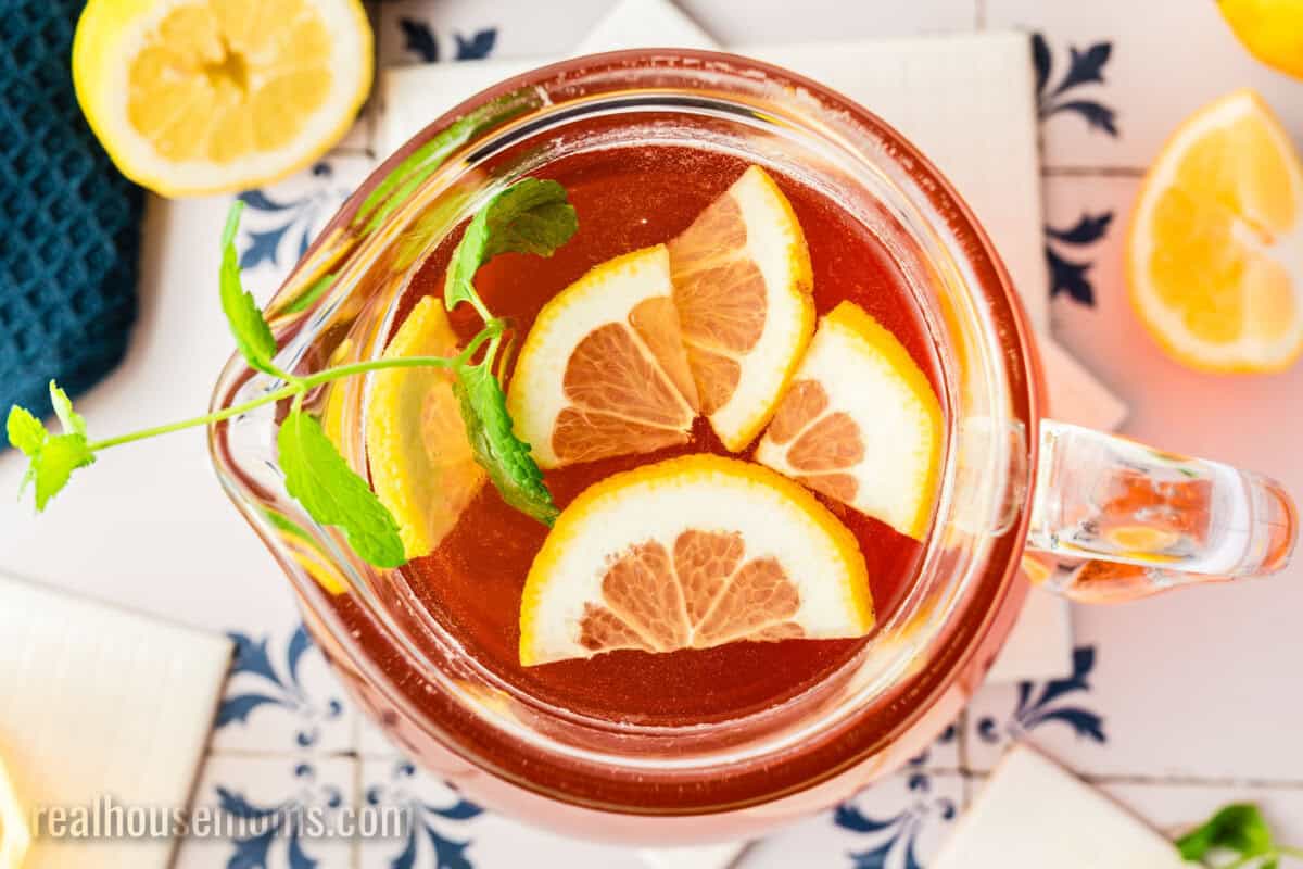 looking down into a pitcher of sun tea with lemons and mint