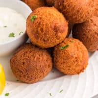 hush puppies piled on a plate with recipe name at the bottom