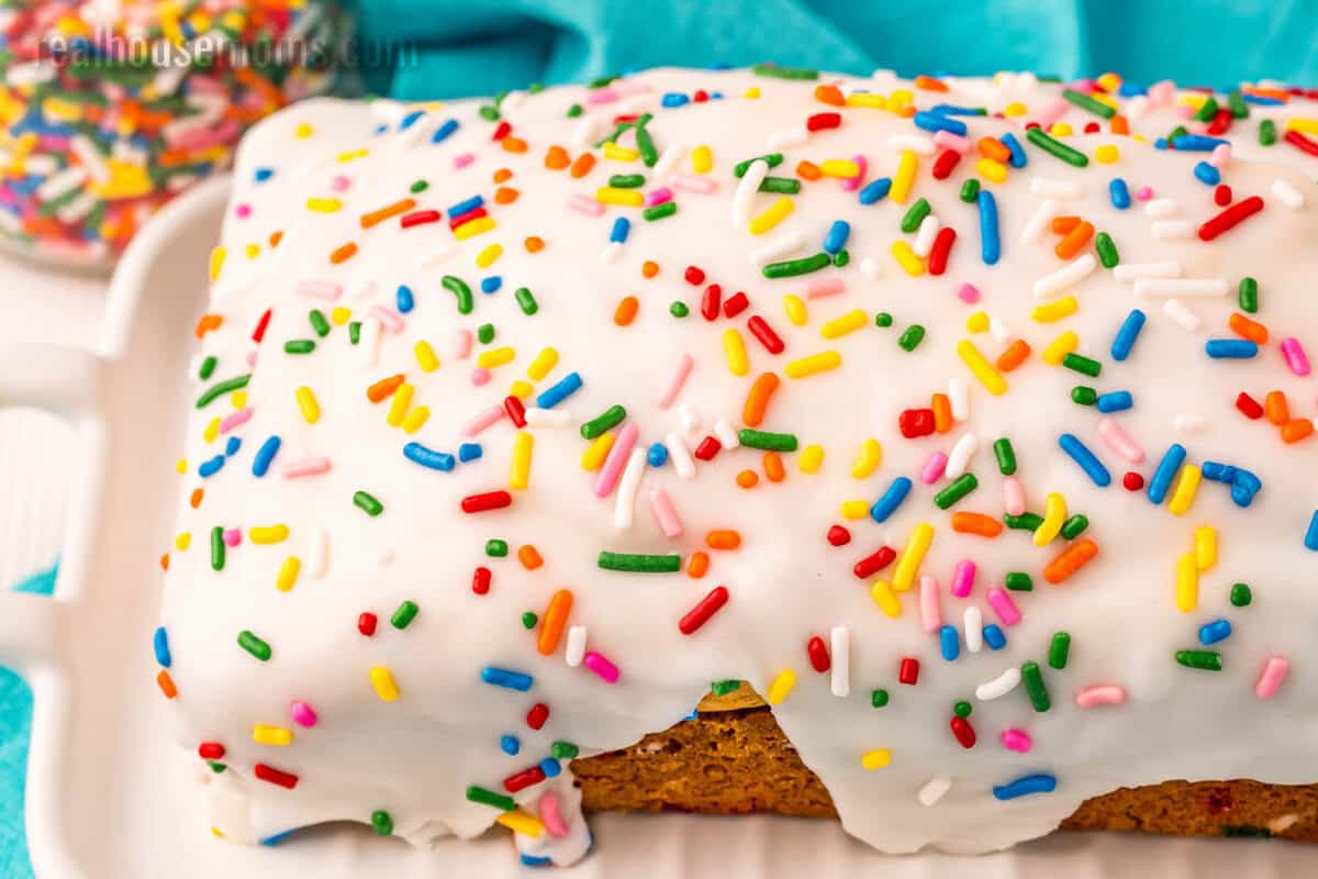 loaf of ice cream bread with vanilla glaze and sprinkles on top