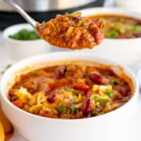 spoonful of instant pot chili over a bowl with recipe name at bottom