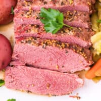 sliced instant pot corned beef on a plate with recipe name at the bottom