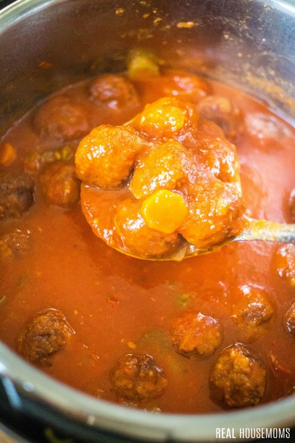 ladle od instant pot meatball soup being taken from instant pot