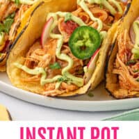 close up of instant pot shredded chicken tacos on a plate with recipe name at the bottom