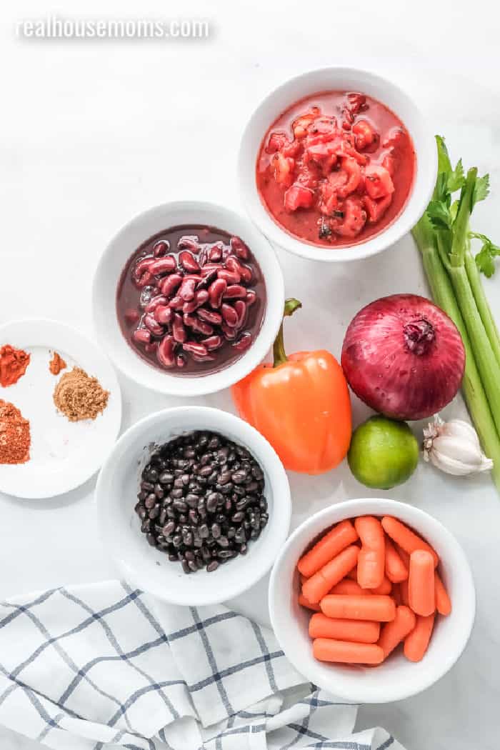 ingredients to make vegetarian chili laid out in bowls