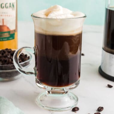 square image of irish coffee in a glass footed mug