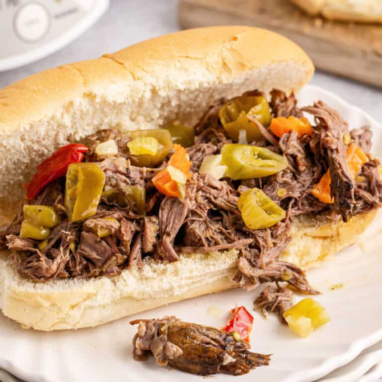 square image of an italian beef sandwich on a white plate