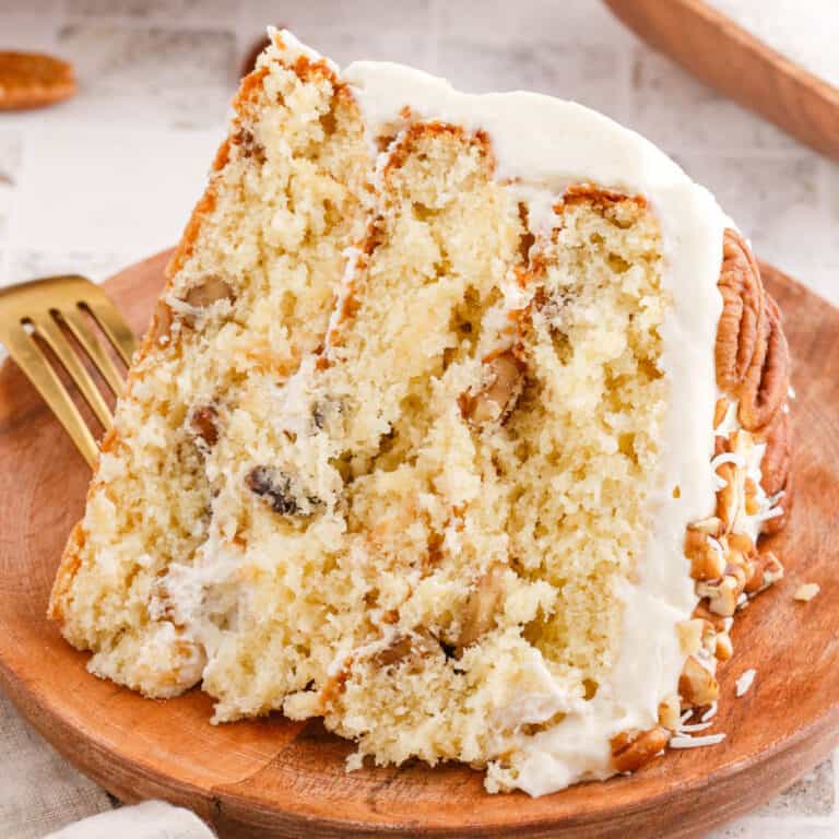 square image of a slice of italian cream cake on a wooden plate