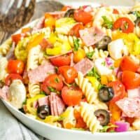 Italian Pasta Salad is a tasty cold pasta salad with mozzarella, salami, peppers, and olives mixed in a tangy Italian dressing. The perfect potluck dish!