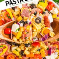 spoons lifting a portion of italian pasta salad from the serving bowl with the title of the post on the top left corner