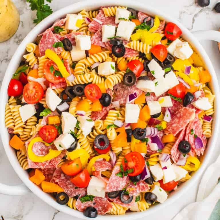 square image of italian pasta salad in a large white serving bowl